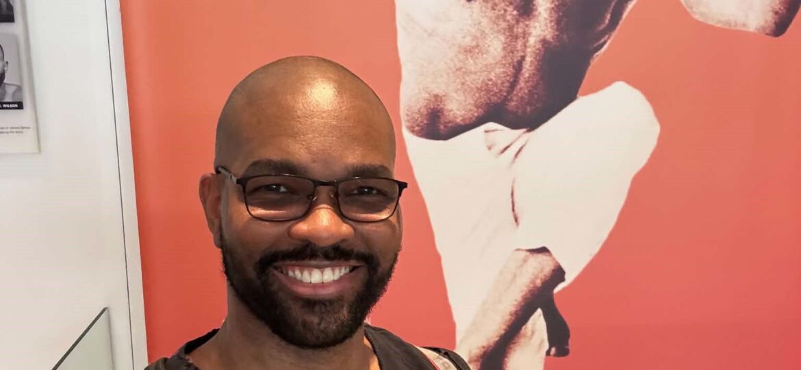 DDT Founder Shawn Short at Ailey in front of Alvin Ailey's Photo in the Lobby